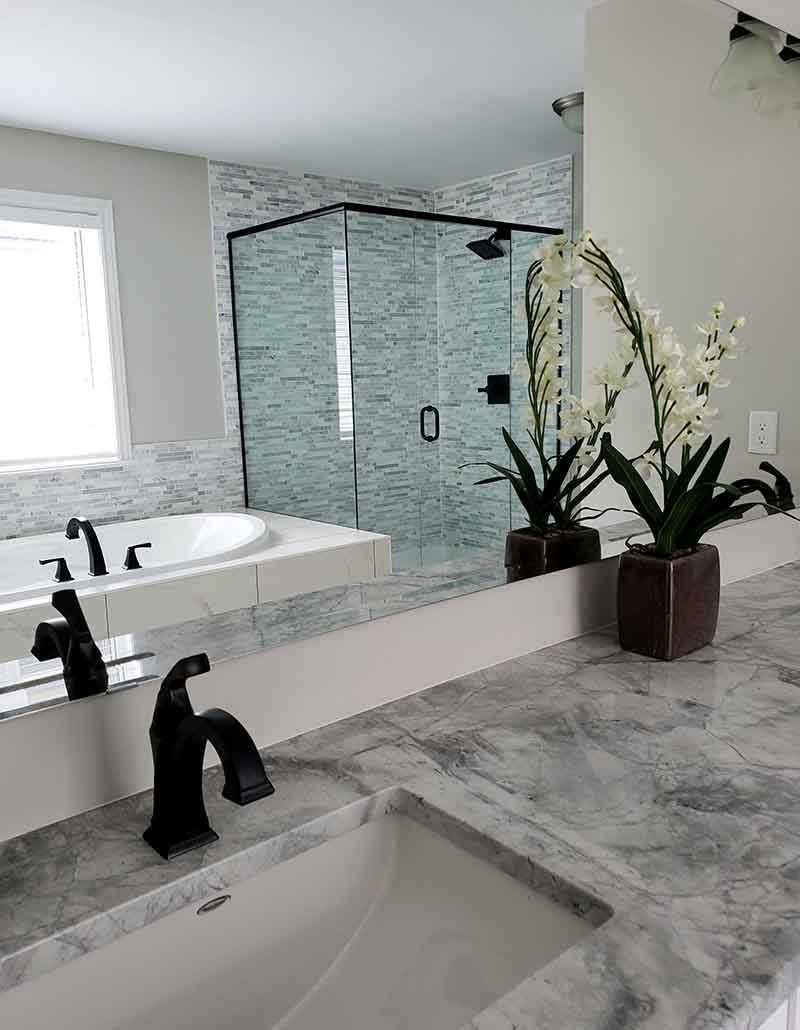 Elegant bathroom remodel with glass shower enclosure, marble vanity, and soaking tub by L.F. Fenimore Plumbing and HVAC in South New Jersey.
