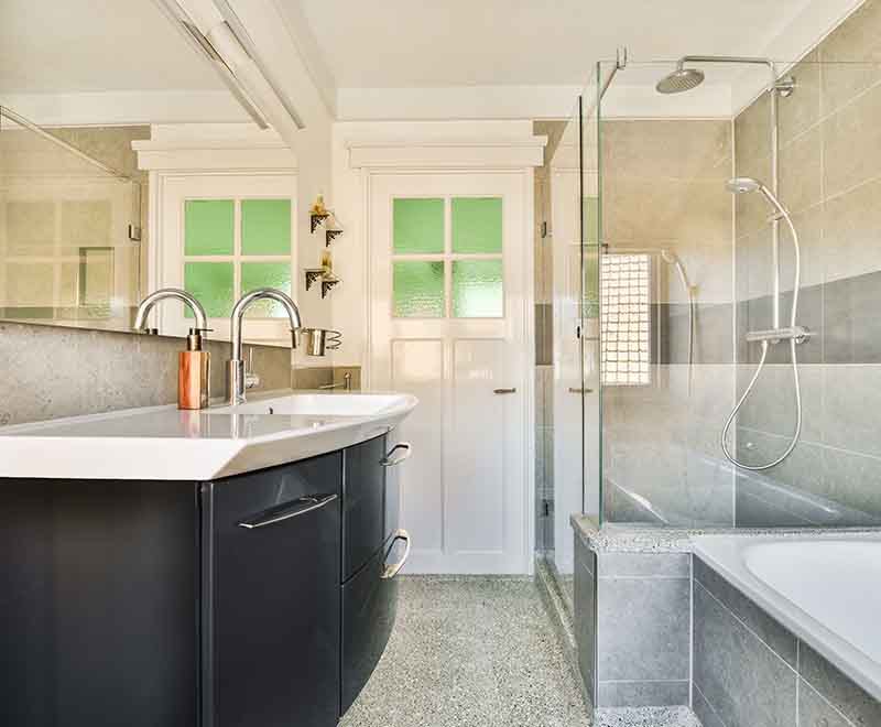 Modern bathroom plumbing installation with dual sink faucets and glass shower by L.F. Fenimore Plumbing and HVAC in South Jersey.