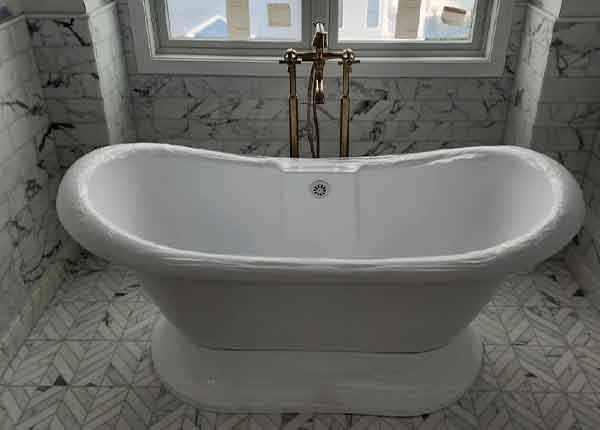 Freestanding bathtub installation with marble tile by L.F. Fenimore Plumbing and HVAC in South New Jersey.