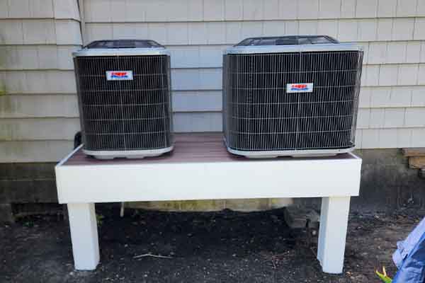 Dual outdoor HVAC condenser units installed on raised platform by L.F. Fenimore Plumbing and HVAC in South Jersey.
