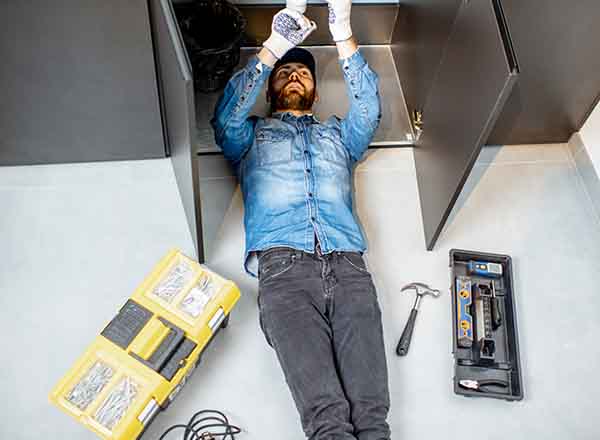 Professional plumber performing sink repair with tools by L.F. Fenimore Plumbing and HVAC in South New Jersey.